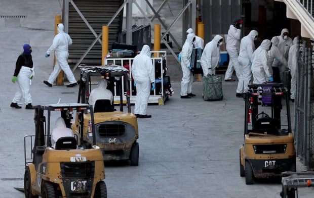 Baggage handlers unload suitcases from the Zaandam in Florida