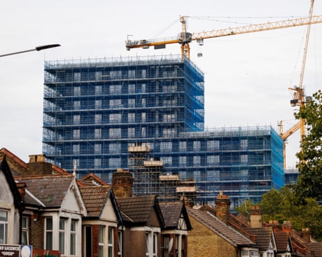 Construction work on an apartment building behind a row of houses