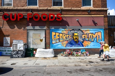 People walk by a mural at 38th Street and Chicago Ave., the area called George Floyd’s Square.