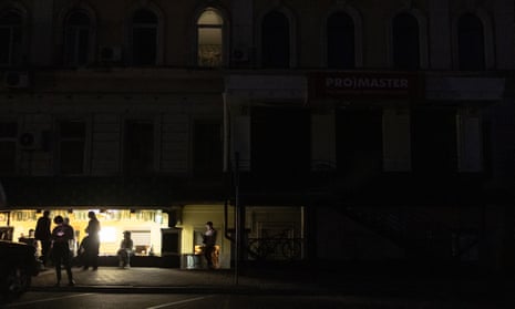People gather outside a cafe during a blackout following Russian attacks on a city's energy infrastructure in Kharkiv, on April 8, 2024, amid the Russian invasion of Ukraine.