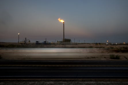 A gas flare is seen in a field at dusk near Mentone, Texas, in August 2019.