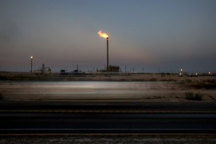 A gas flare is seen in a field at dusk near Mentone, Texas, in August 2019.