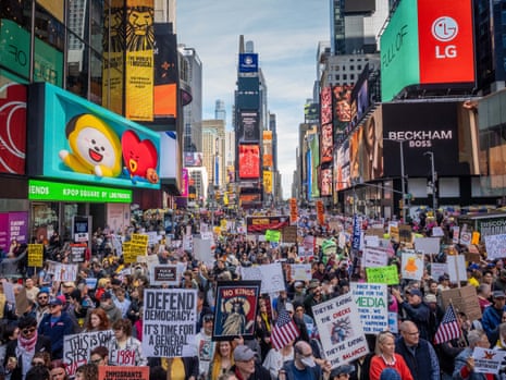 People walk with placards down Times Square. Demonstrators march through Midtown during the No King's Day protest on Saturday, denouncing monarchy and inherited power while calling for global democratic reform. No Kings Day Protest In NYC, New York, USA - 18 Oct 2025