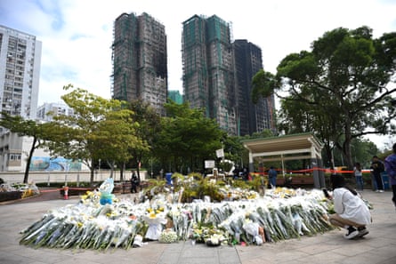 Flowers laid for the victims of a deadly fire at the Wang Fuk Court residential estate in Hong Kong