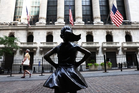 A pedestrian walks near the “Fearless Girl” statue in front of the New York Stock Exchange (NYSE) at Wall Street on July 23, 2020 in New York City.