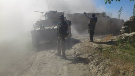 Soldiers standing beside tank