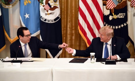 Steve Mnuchin shows Donald Trump a pre-paid debit card to distribute coronavirus aid during a meeting at the White House on 19 May. 