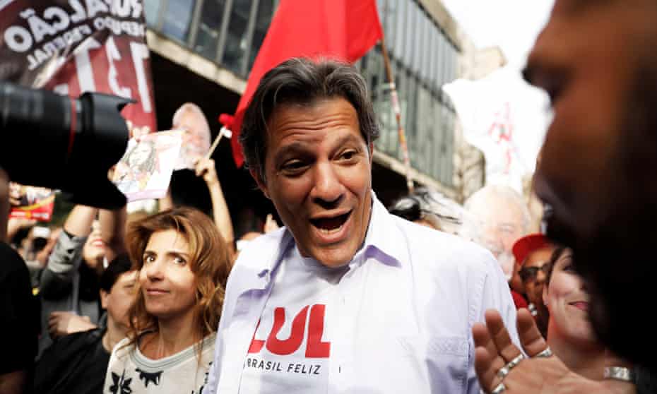Fernando Haddad, with his wife Ana Estela, flashes the victory sign during a rally in São Paulo. One recent poll showed that more than a third of them have no idea who he is.