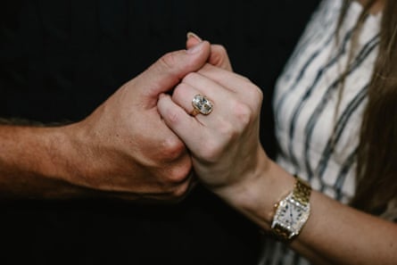 close up of a couple holding hands with one of them wearing a giant engagement ring