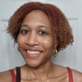 a woman with gold hoop earrings smiling