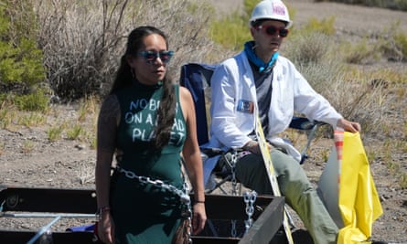 woman in dress that says ‘no burn on a dead planet’, man in hard hat and lab coat