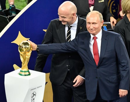 Russian President Vladimir Putin caresses the trophy next to Fifa president Gianni Infantino at the 2018 World Cup final