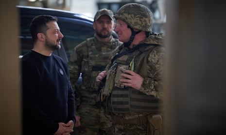 Russia-Ukraine struggle reside: Putin and Zelenskiy go to troops close to frontline | Russia 1 Zelenskiy in a dark sweater speaking to a soldier in combat fatigues.