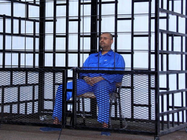 Saif Gaddafi attends a hearing behind bars in a courtroom in Zintan, May 2014.