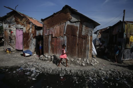A girl walks by a pool of waste water, used as a toilet by residents in the Cite Soleil district of Port-au-Prince, Haiti
