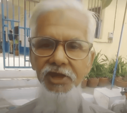 Face of an older man with white hair, beard and glasses.