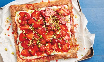 A square strawberry and basil tart on baking paper on top of a baking tray