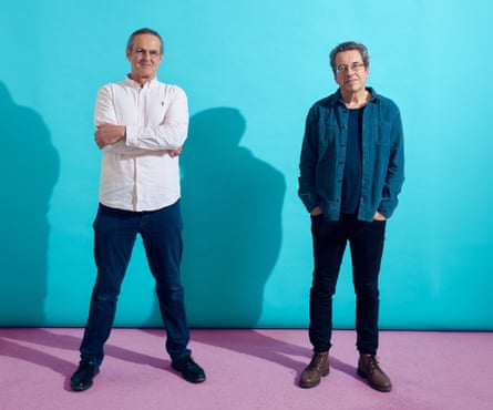 Guardian writer George Monbiot (on right) standing alongside artist and conspiracy theorist Jason Liosatos, on purple floor with turquoise background, March 2024