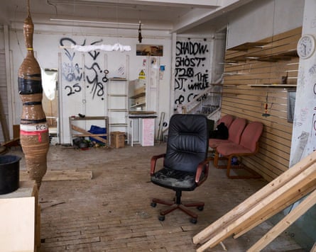 A punching bag made of tape sits behind a plywood ramp in an abandoned office