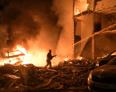 Emergency services personnel work to extinguish a fire following Russian missile attacks in Kyiv, Ukraine.