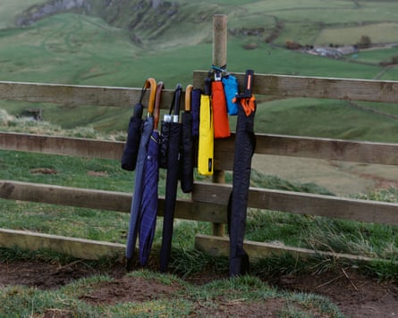 Range of umbrellas lined up against a fence