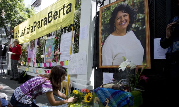 A woman places flowers on an altar set up in honor of Berta Cáceres during a demonstration outside Honduras’ embassy in Mexico City on 15 June 2016.