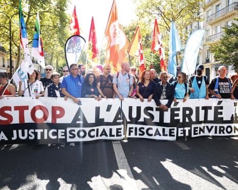 People marching behind a large banner
