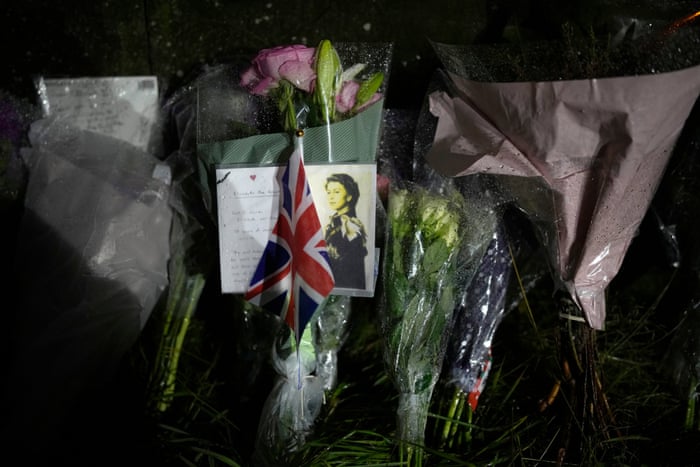Floral tributes following the death of the Queen are placed outside the gates of Holyrood Palace in Edinburgh.