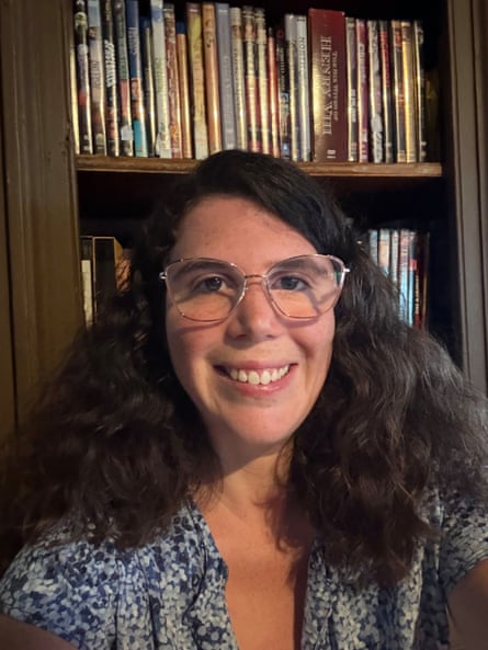 A woman standing in front of shelves of DVDs.
