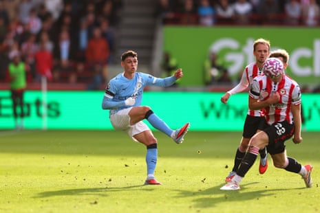 A bandaged Phil Foden crosses the ball.