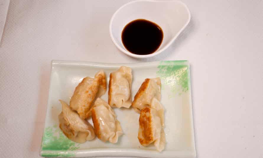 Pan-fried dumplings and a small pot of black sauce