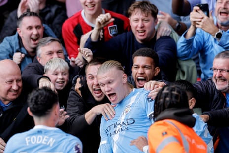 Haaland celebrates with fans after scoring.