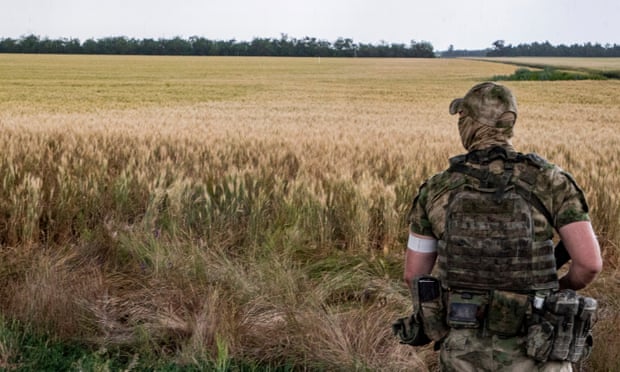 A Russian soldier keeps watch in front of a wheat field near Melitopol in the Zaporizhzhia region of Ukraine
