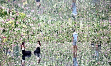 People explore a floral artwork