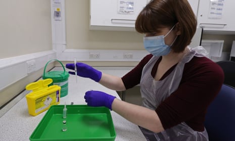 An NHS pharmacy technician at the Royal Free hospital, London, simulates the preparation of the Pfizer vaccine