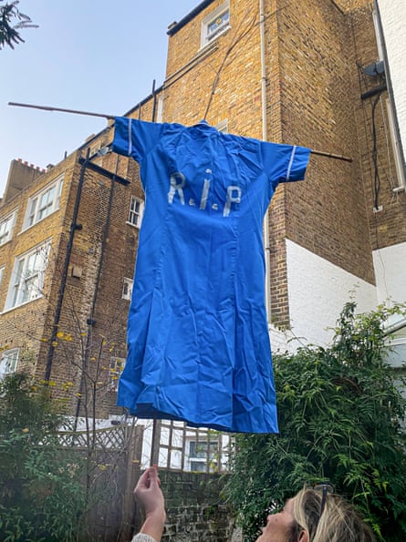 A nurse hangs her uniform on the line with ‘RIP’ written on the back
