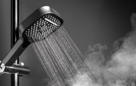 A shower head with running water and soothing steam in a bathroom.