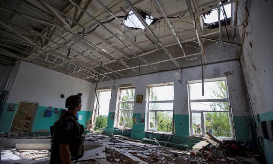 Russia-Ukraine war: Moscow warns US over rocket shipments to Kyiv; Ukraine losing up to 100 soldiers a day – live 3 A police officer checks a school during an evacuation of local residents between shelling in the town of Marinka, in Donetsk region, Ukraine.