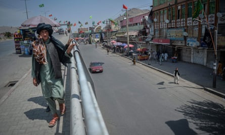 Afghan boy walks on bridge above empty road in Kabul