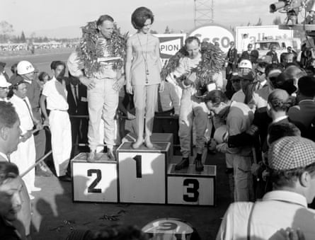 Race winner Dan Gurney on the No 2 podium with runner-up John Surtees on No 3, as Lorenzo Bandini stands to the side