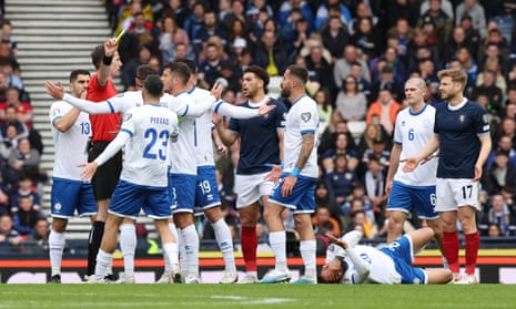 Scotland's Stuart Armstrong is shown a yellow card by referee Duje Strukan.