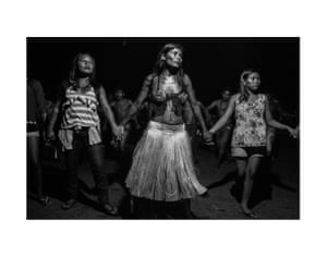 Guerreiros Munduruku de Priscila Tapajowara, povo Tapajó, Amazônia, Brasil Mulheres e homens Munduruku dançam e cantam em um ritual na aldeia Katõ na região amazônica. Priscila Tapajowara (também conhecida como Adrielle Priscila da Silva Tavares) foi a primeira indígena a se formar na Faculdade Paulus de Tecnologia e Comunicação, tendo cursado produção audiovisual. Desde então, atua como diretora de cinema, documentarista desde 2013 e comunicadora na Mídia Índia.