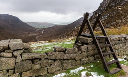 Wooden stile over the Mourne Wall at Hare’s Gap with views down Trassey Track. Mourne Mountains, N.Ireland.PY7BHD Wooden stile over the Mourne Wall at Hare’s Gap with views down Trassey Track. Mourne Mountains, N.Ireland.