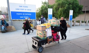 A women pushes a cart with luggage and boxes on entry from Mexico into the United States at the San Ysidro Land Port Entry in San Ysidro, California