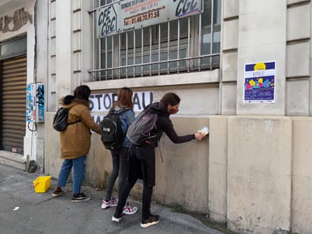 Camille, Natacha and Cindy glueing up posters in Paris demanding an end to femicides
