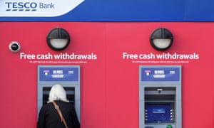 A customer uses an RBS branded automated teller machine (ATM), at a Tesco Bank cash point