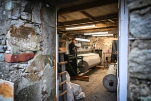 MacLeod stands behind a weaving loom in the workshop