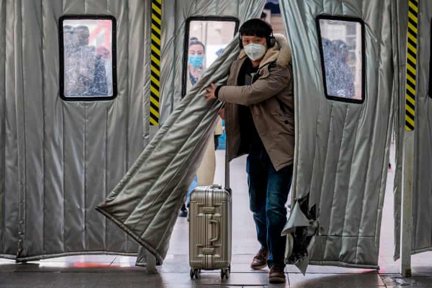 A passenger wearing a protective mask enters Beijing West railway station on 24 January 2020.