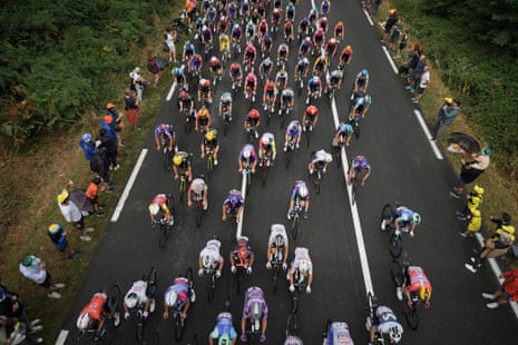 Spectators line the side of the road and cheer on the riders as they pass at the start of the 14th stage of the 2025 Tour de France.