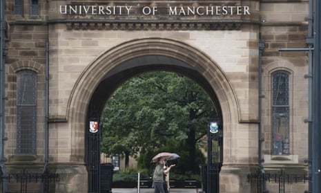 People walk past entrance to Manchester University holding umbrellas